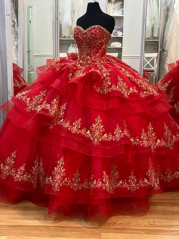 Red Quinceañera dress with ruffles on skirt and gold details